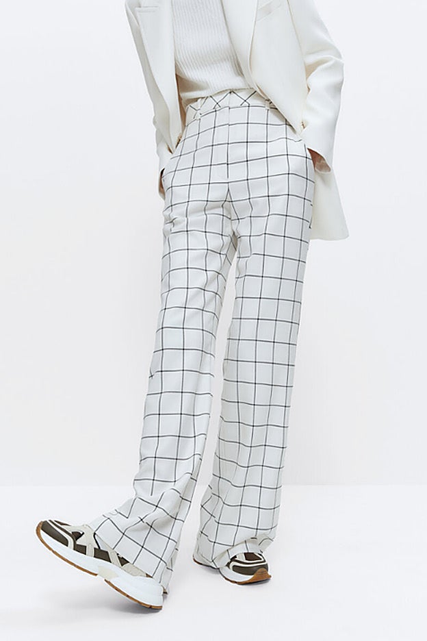 Pantalones blancos con estampado a cuadro ventana de Uterqüe.