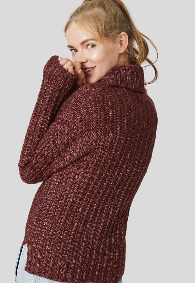 Este jersey de punto grueso en color granate cuenta con aberturas laterales y bajo asimétrico. Tiene un precio de 17,99 euros.