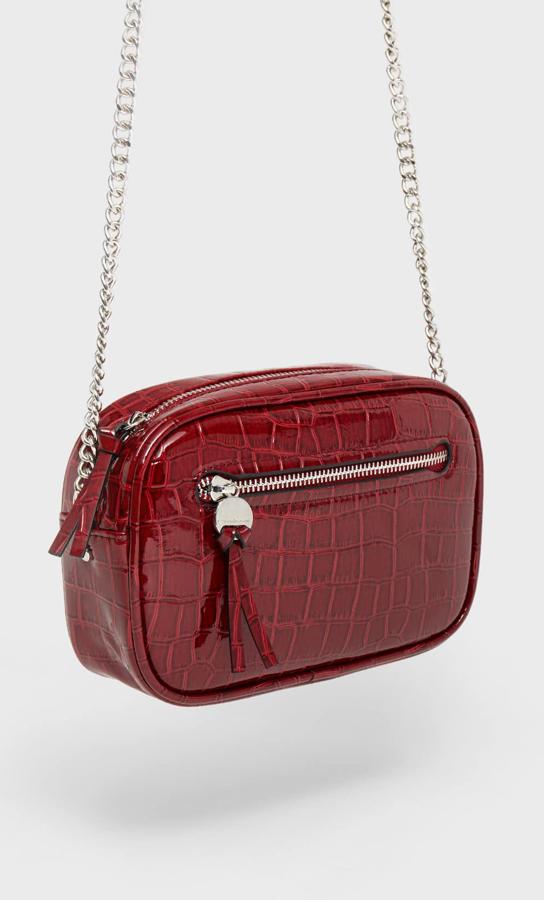 En color granate y diseño redondeado, este bolso bandolera efecto coco cuenta con asa de cadena y tiene un precio rebajado de 9,09 euros.