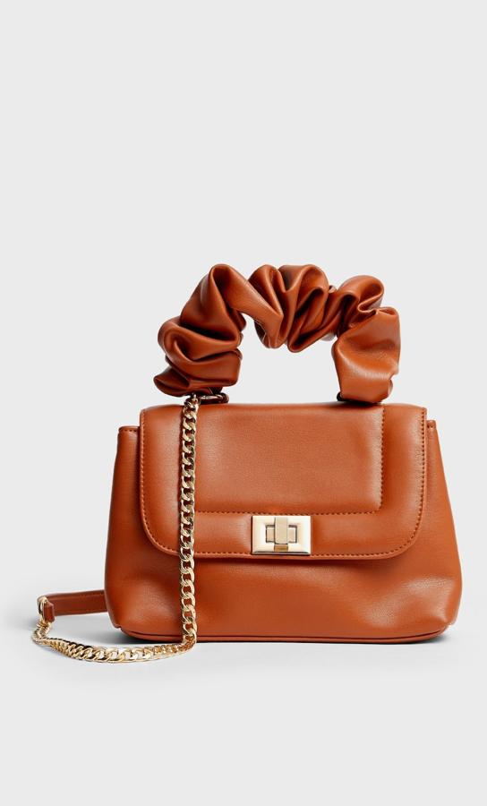 En color marrón, este bolso pequeño con asa corta arrugada y larga con detalle de cadena dorada tiene un precio de 15,99 euros.