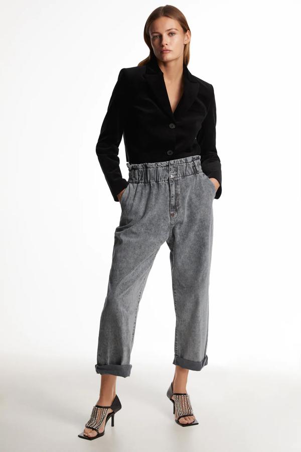 De la 32 a la 44. Vaqueros de tiro alto y cintura elástica fruncida. Cierre que combina cremallera y botones metálicos. Efecto lavado.