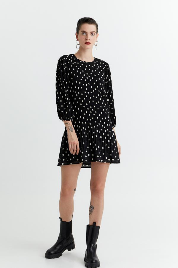 Este vestido plisado corto de color negro con topos blanco tiene un precio de 25,99 euros.