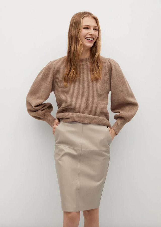 De tiro alto y en efecto piel, esta falda midi de Mango con diseño lápiz corto viene con bolsillos laterales y costuras vistas. Tiene un precio de 25,99 euros y está disponible entre las tallas 32 y 44.