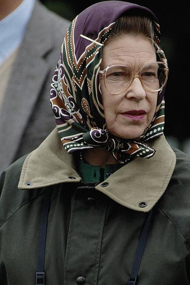 La reina de Inglaterra ha hecho del binomuio Barbour- pañuelo de seda una de sus señas de identidad.