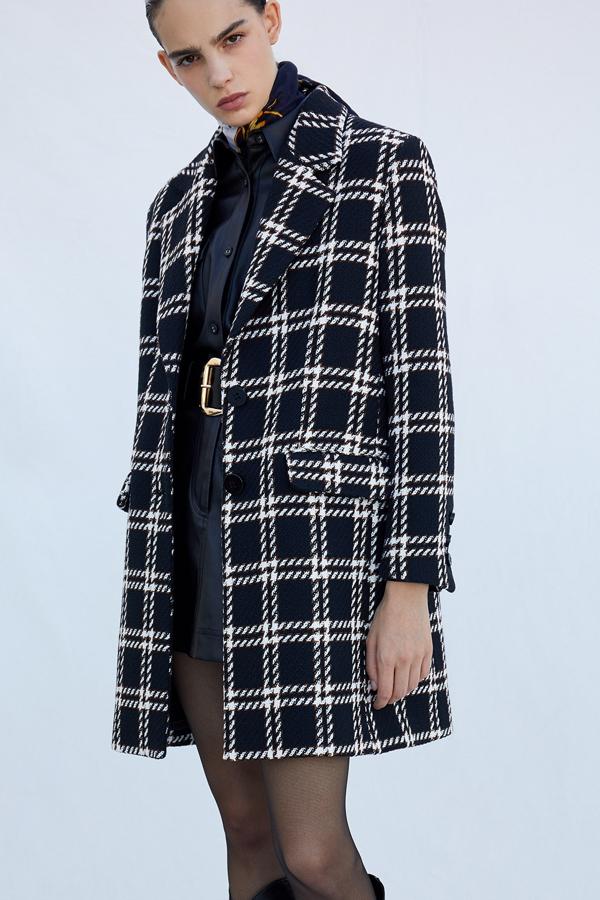Con estampado de cuadros tartán en blanco y negro, este abrigo con cuello de solapas y bolsillos tiene un precio rebajado de 49,99 euros.