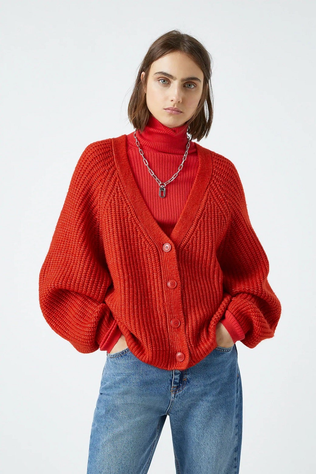 Cárdigan rojo básico para combinar con todos los vaqueros. (25,99 euros con 23% de descuento).