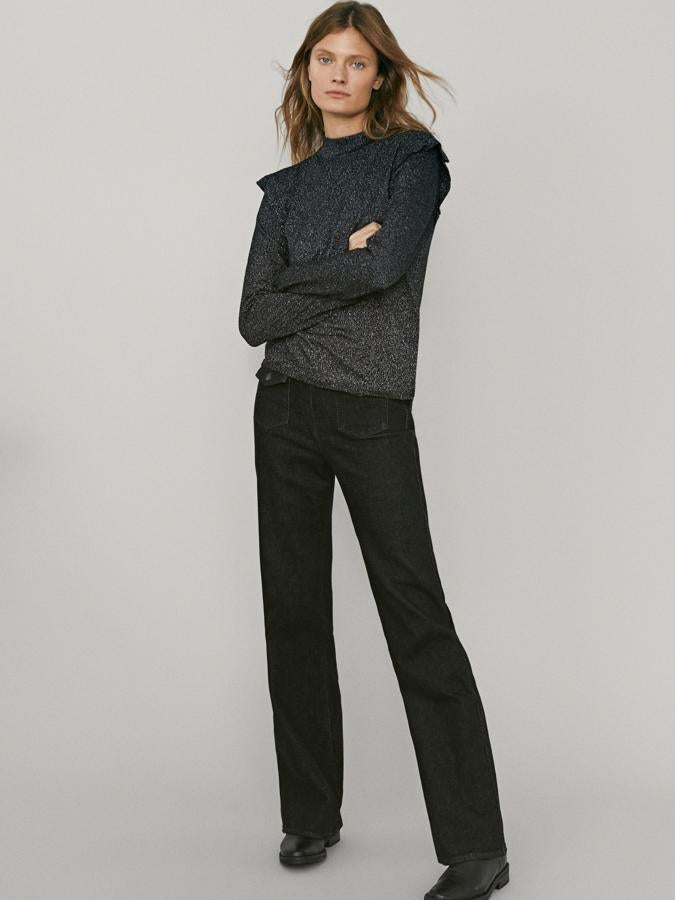 Con detalle de volantes en el hombro y cuello perkins, este jersey en blanco y negro con hilo metalizado y acabados acanalados costaba 49,95 euros y ahora podemos comprarlo por 39,95 euros y está disponible entre las tallas XS y XL.