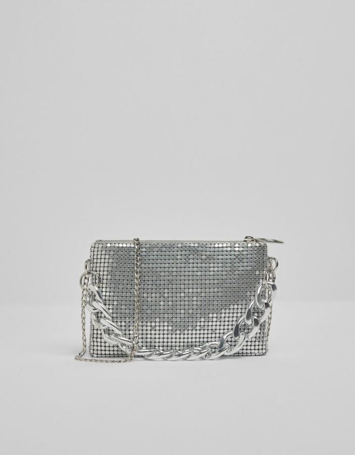 En plateado con exterior tipo malla, asa corta de maxicadena y asa larga de cadena convencional, este bolso con cremallera superior de Bershka costaba 17,99 euros y ahora podemos comprarlo por 9,99 euros.