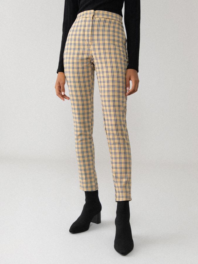 Con cuadros en negro y mostaza, este pantalón con goma elástica en la espalda y cierre delantero con cremallera y pasador costaba 14,99 euros y ahora podemos encontrarlo por 9,99 euros entre las tallas XS y XL.