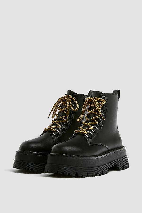 Este zapato tipo botín en color negro con cordones en contaste de color amarillo cuenta con una altura de la suela de 5,5 centímetros y cierre mediante cremallera en el interior. Tiene un precio de 29,99 euros.