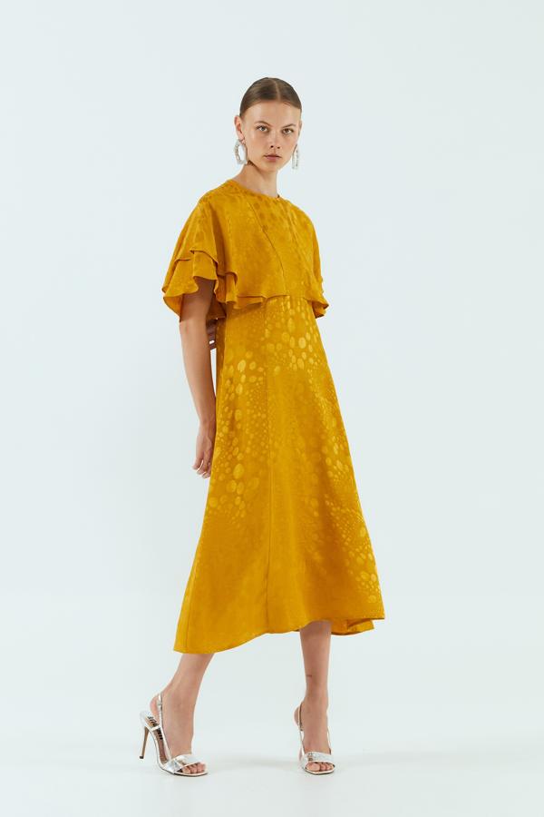 Vestido jacquard en color mostaza, falda de vuelo y volantes en la parte superior. Rebajado de 35,99 a 15,99 euros.