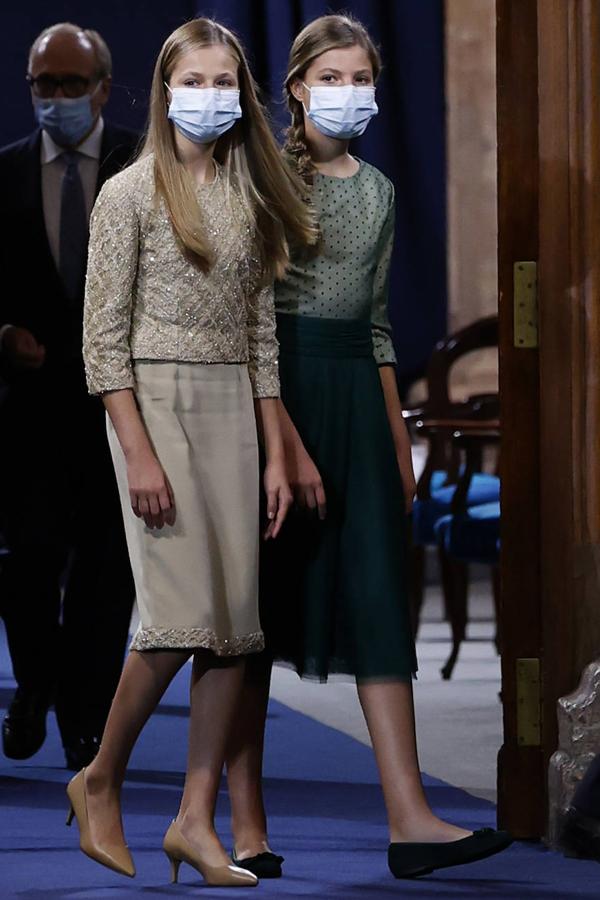 La heredera al trono dejaba atrás su apariencia de niña y lucía un conjunto en color caramelo con pedrería y por primera vez lo acompañaba con unos kitten heels con tacón de aguja. Su hermana combinaba un cuerpo de tul plumetti en tono verde claro con una falda con fajín en un tono más oscuro. Ella por el contrario llevaba zapato plano.