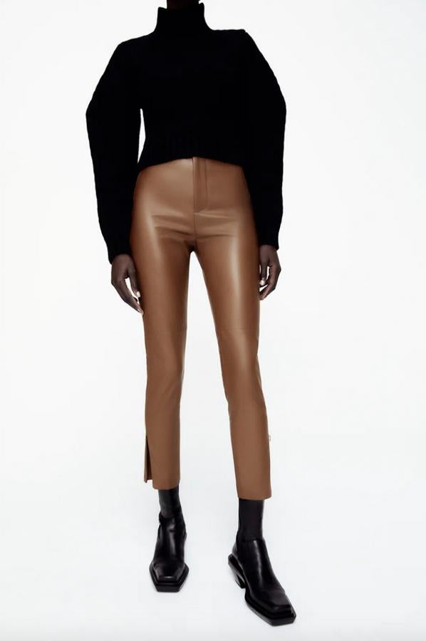 Disponible en color cuero, arena y negro, este pantalón en efecto piel de Zara viene con bajo tobillero con laterales abiertos y cierre de cremallera y botón. Cuesta 19,95 euros y está disponible entre las tallas XS y XXL.