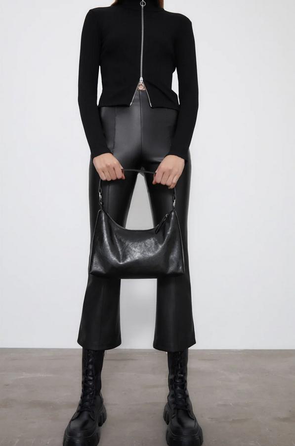 Diseño flare con tiro alto y cintura elástica para estos leggings en efecto piel de Zara con bajo evasé y cierre lateral con cremallera. Disponible entre las tallas XS y XXL, cuestan 19,95 euros.