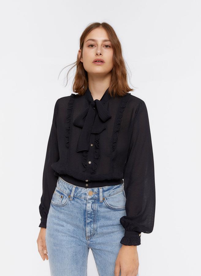 En color negro, confeccionada en tejido jacquard, con lazo en el cuello, cierre frontal de botones y mangas largas acabadas en puño abotonado, esta camisa ha pasado de 79 euros a 49,95 euros y solo queda en la talla M.