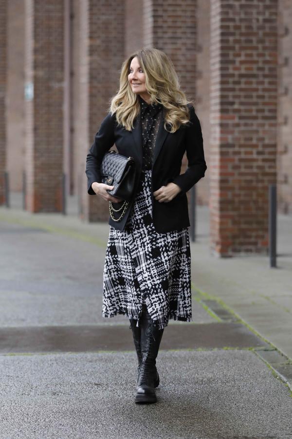 El eterno binomio blanco y negro nunca deja de sorprendernos por su alto nivel de acierto. En este caso una falda midi de lana de tweed combinada con una americana de vestir es perfecta para un look de oficina impecable. El toque definitivo lo da una blusa transparente y un par de botas de combate en cuero negro.