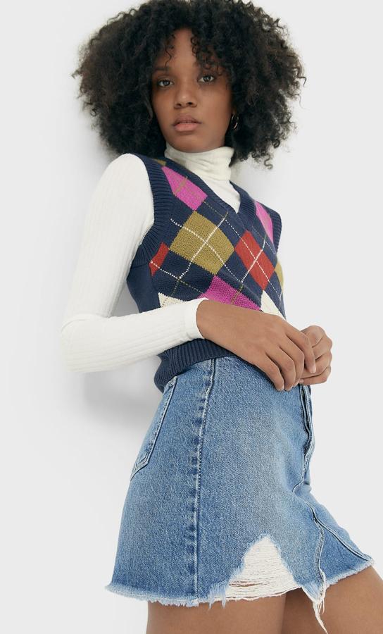 En azul marino con rombos en caqui, teja y rosa intenso, este chaleco cropped con cuello de pico acanalado, al igual que el bajo y las mangas sisa, tiene un precio de 19,99 euros y está disponible entre las tallas XS y XL.