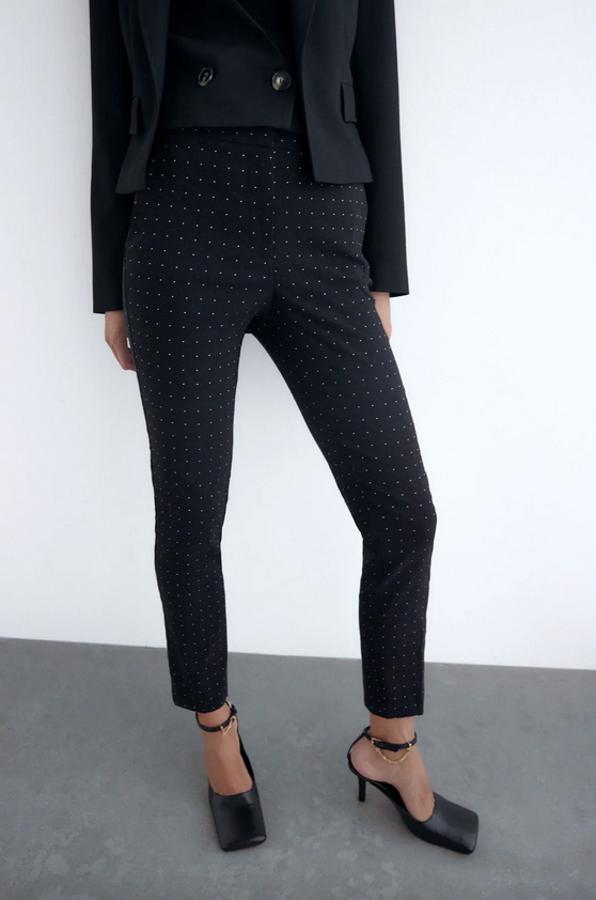 En jacquard, con estampado de lunares a contraste, este pantalón negro de tiro alto con bolsillos delanteros y falso bolsillo de vivo en la espalda costaba 25,95 euros y ahora podemos encontrarlo entre las tallas 15,99 euros entre las tallas XS y L y en la XXL.