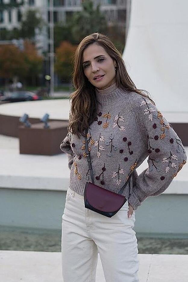 Look con jersey con abalorios de Zara, pantalón blanco y bolso burdeos.