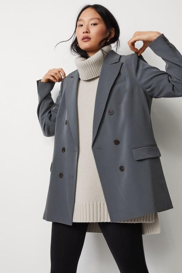 De venta exclusiva en la web de H&M, esta americana de doble botonadura en verde grisáceo oscuro viene con solapas de pico y botones decorativos en los puños, bolsillos superiores, bolsillos delanteros con solapa y abertura trasera. Cuesta 39,99 euros y está disponible entre las tallas XS y XL.