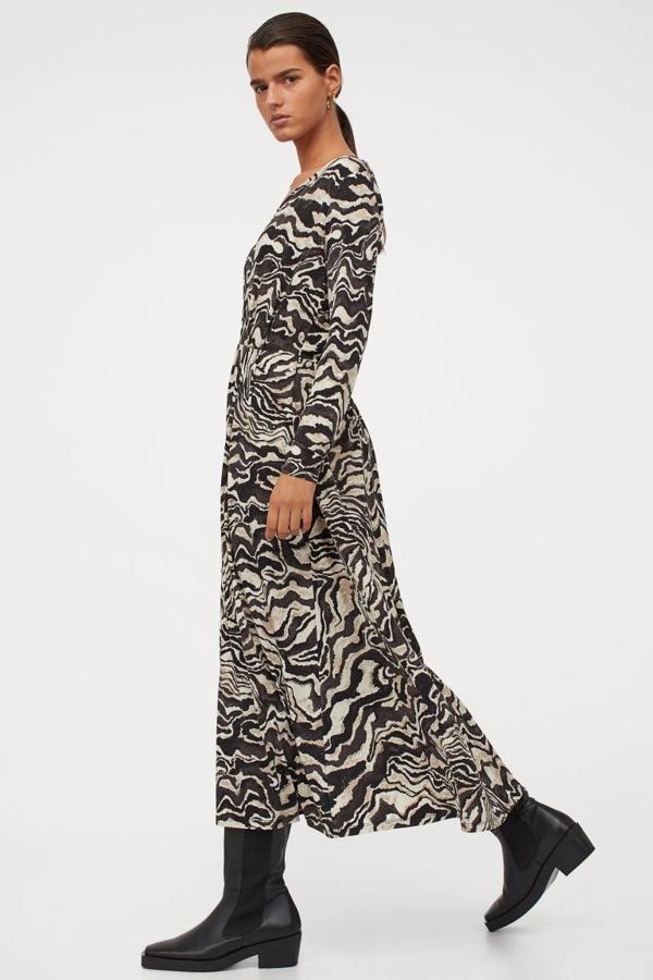 Este vestido largo de punto con escote de pico, costura con pliegues en la cintura y mangas largas viene con estampado en crudo y negro y cuesta 39,99 euros. Está disponible entre las tallas XS y XL.