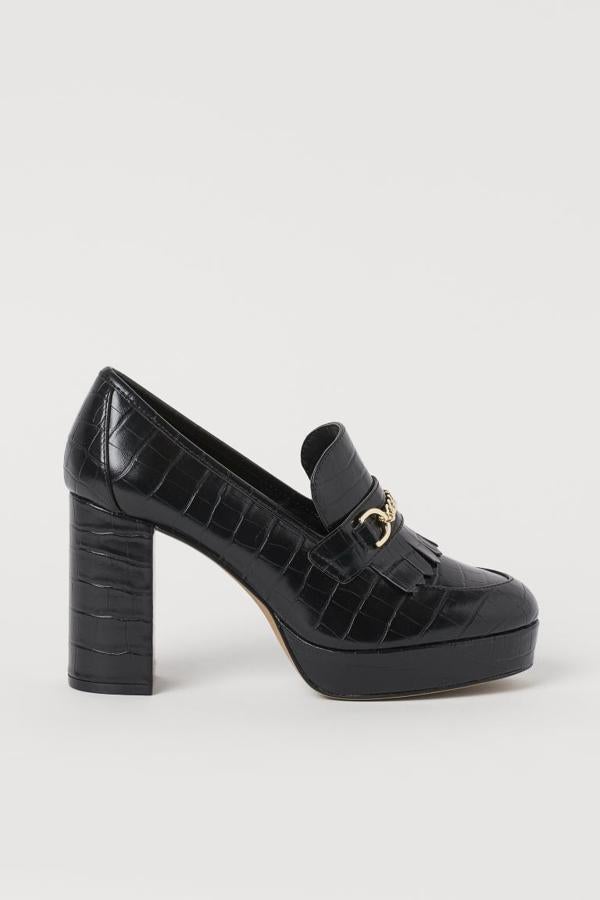 En piel sintética grabada, con tacón grueso revestido de 9,5 centímetros y plataforma, estos mocasines de H&M viene con flecos y cadena de metal decorativa en el empeine. Podemos encontrarlos entre los números 35 y 42 menos en el 37, por 39,99 euros.