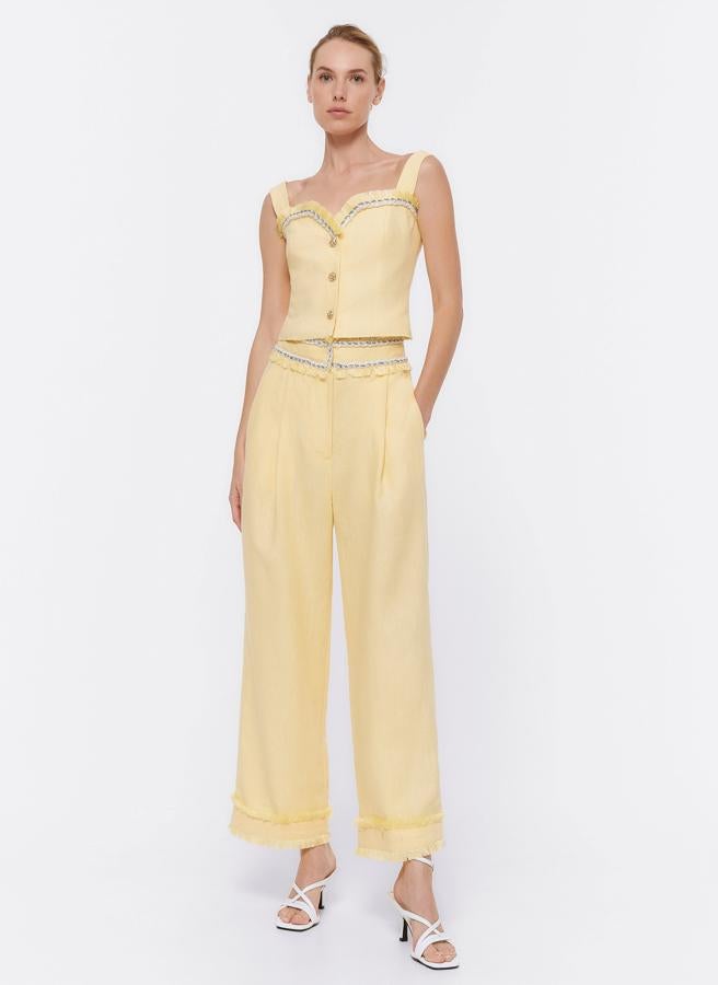 Este conjunto en lino amarillo puede convertirse en tu mejor aliado para los eventos de día de la primavera. El top está rebajado a 39.95 euros y el pantalón tobillero, a 34.95 euros.