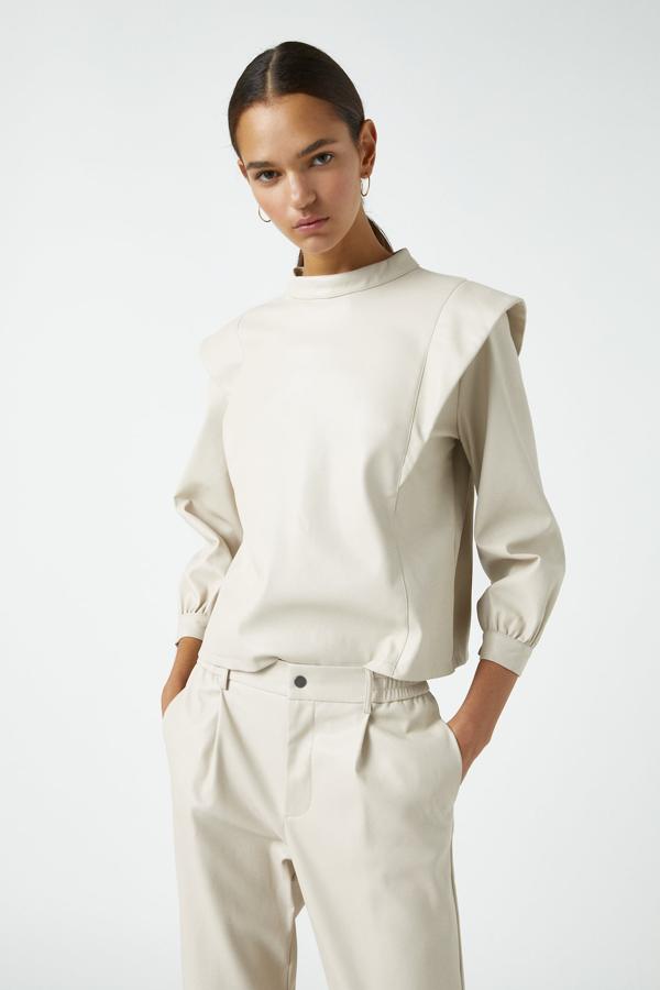 En color blanco hielo, esta camisa de efecto piel con detalle de volumen en los hombros también ha llegado a las rebajas y tiene un precio de 5,99 euros.