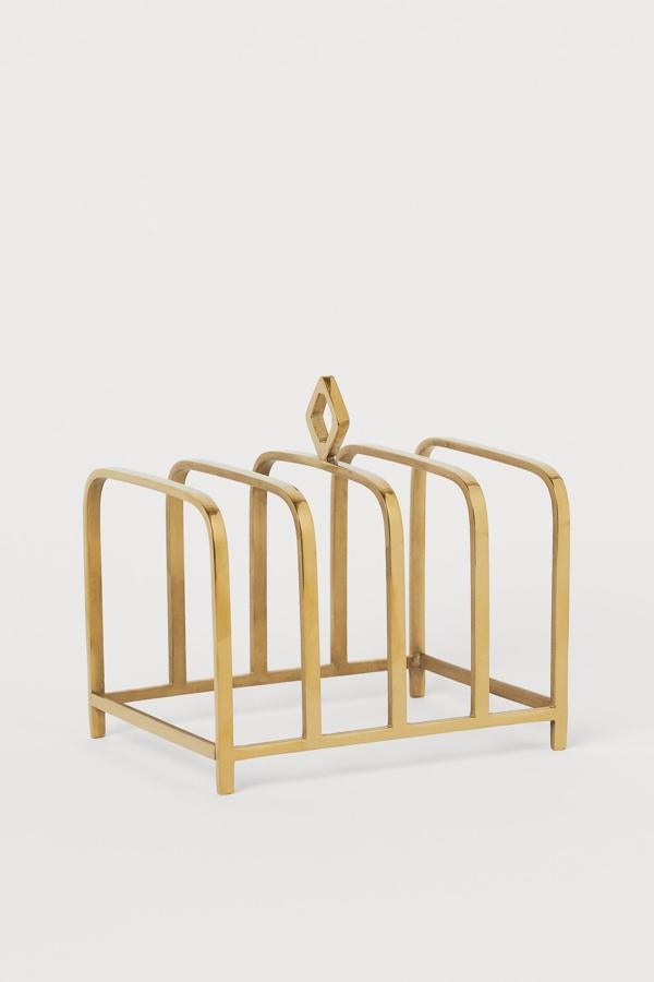 Disponible en negro o dorado, este soporte para tostadas tiene una altura de 9 centímetros, un ancho de también de 9 y un largo de 12. Tiene un precio de 12,99 euros.