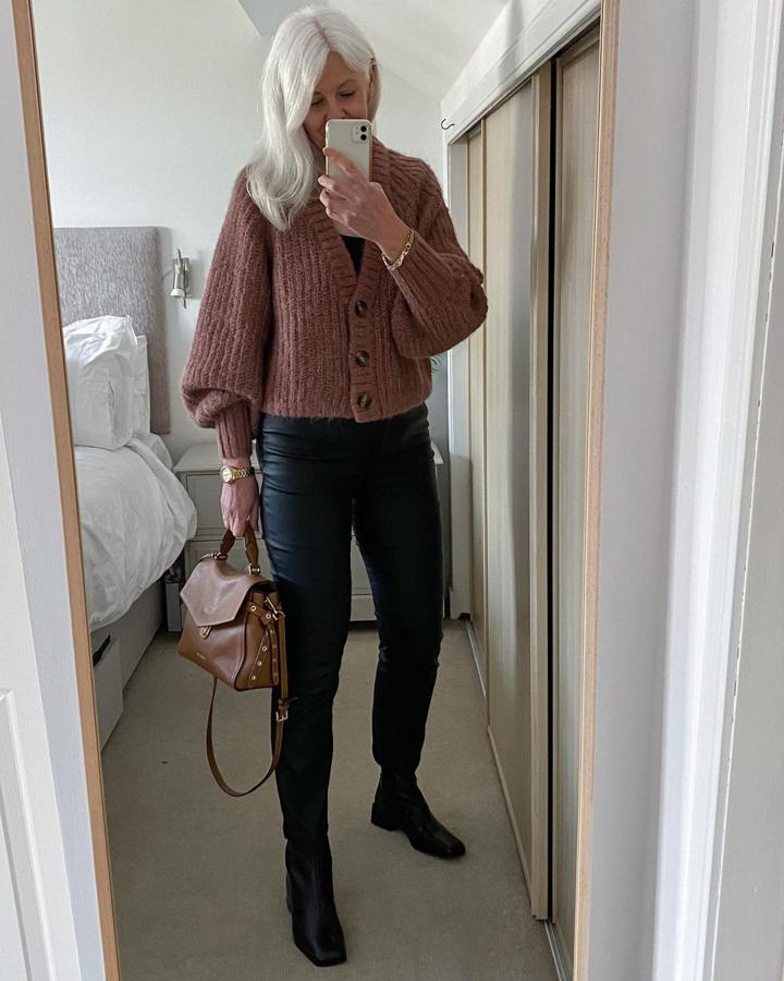 La tendencia de la chaqueta de punto también ha llegado a las influencers 'over 50' y Valerie la ha probado con este modelo marrón de mangas abullonadas de H&M que comjuntó con pantalones efecto piel negros.