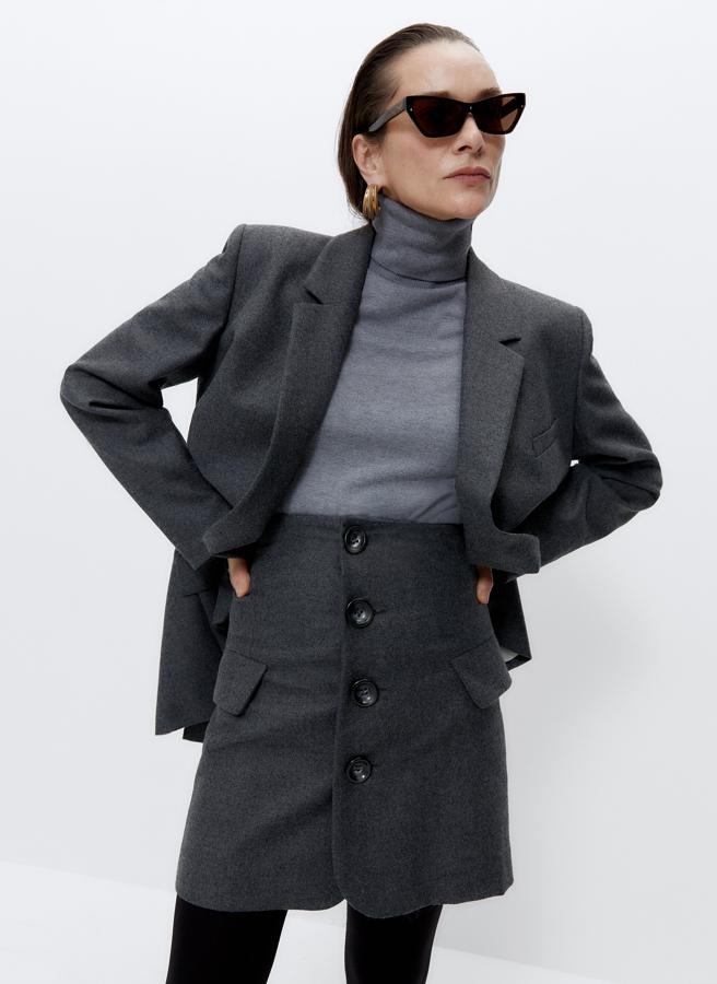 Confeccionada en tejido italiano de alta calidad, esta falda mini el gris oscuro con botones decorativos en el frontal y bolsillos laterales con tapetas ha pasado de 79 euros a 39,95 euros. Está disponible en las tallas S y L.