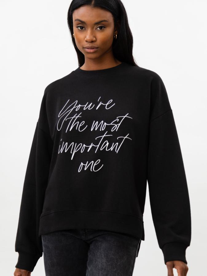 Con estampación de texto a contraste en blanco, esta sudadera negra de manga larga y cuello redondo con bajos con aberturas laterales cuesta 6,99 euros y está disponible entre las tallas S y XL.