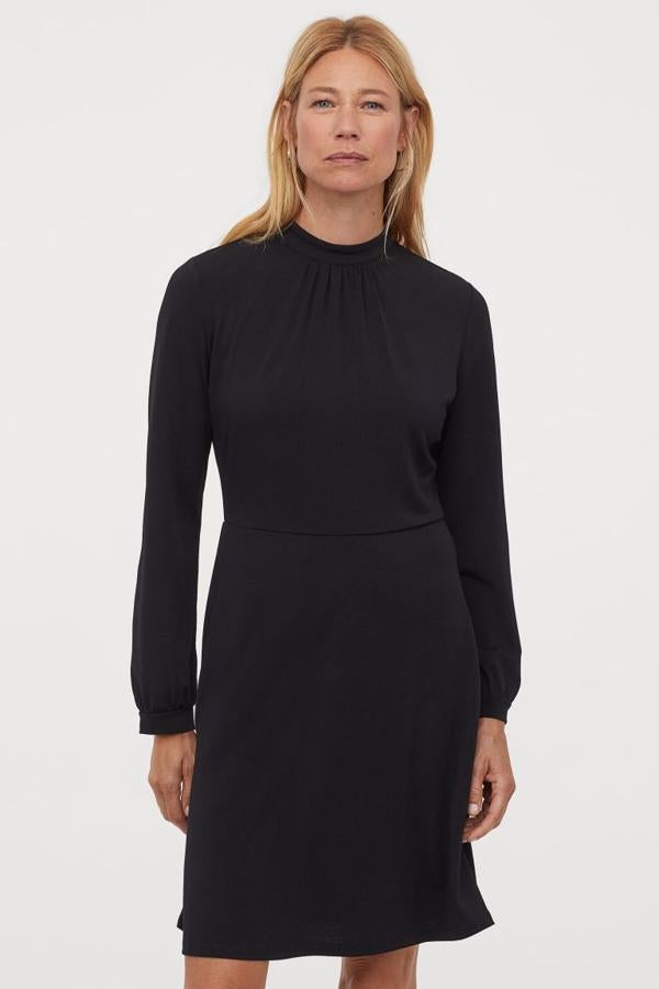 Diseño corto de punto con pliegues decorativos en el cuello para este vestido negro de manga larga con botón en la nuca, puños y costura en la cintura. De 19,99 euros ha pasado a costar 7,99 euros y está disponible entre las tallas XS y XXL.