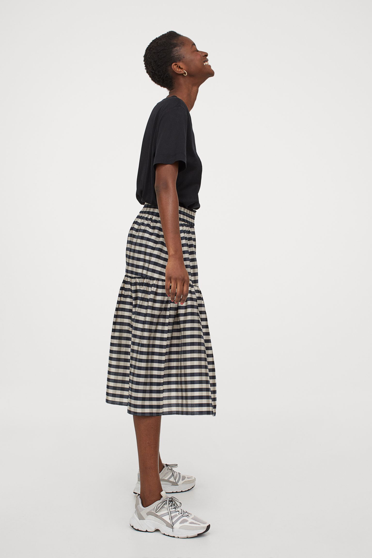 Falda midi con cuadros vichy, talle alto con elástico revestido en la cintura y costura fruncida para dar vuelo y movimiento. Una falda de lo nuevo de H&M con mucha personalidad. (29,99 euros).