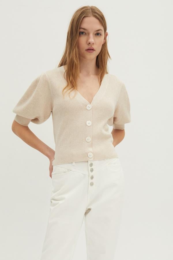 De manga corta y en tejido de canalé, esta chaqueta con cierre de botones está disponible en negro, piedra y blanco y tiene un precio de 15,99 euros.