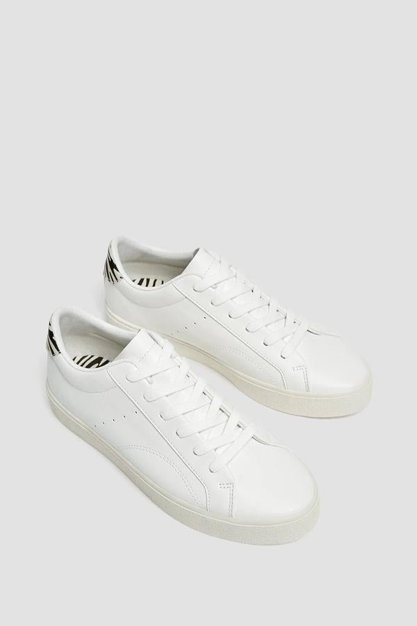 Pull & Bear nos propone estas zapatillas blancas tipo bamba con talonera con animal print de cebra y cierre mediante cordones. Tienen un precio de 19,99 euros.