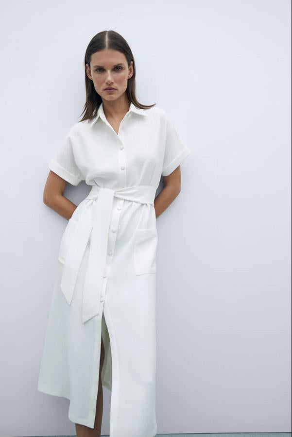En blanco roto, este vestido camisero con cuello solapa, manga corta acabada en vuelta y bolsillos delanteros de plastrón está confeccionado con al menos un 50% de poliéster reciclado. Viene con detalle de cinturón a tono y cierre frontal de botones combinados. Está disponible entre las tallas XS y XL por 39,95 euros.