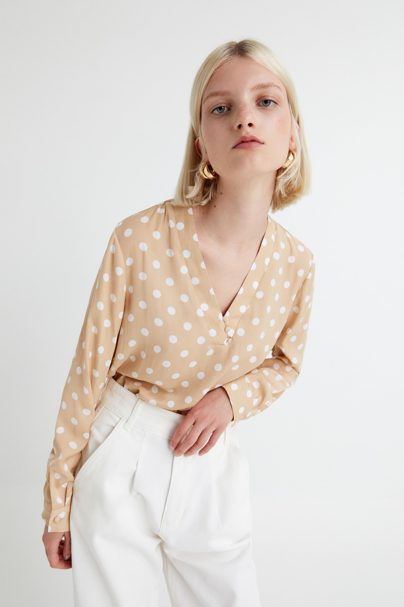 No hay primavera sin lunares, y esta blusa con escote a pico cruzado y cierre de botones de lo nuevo de Sfera es perfecta para caer en la tendencia. (15,99 euros).