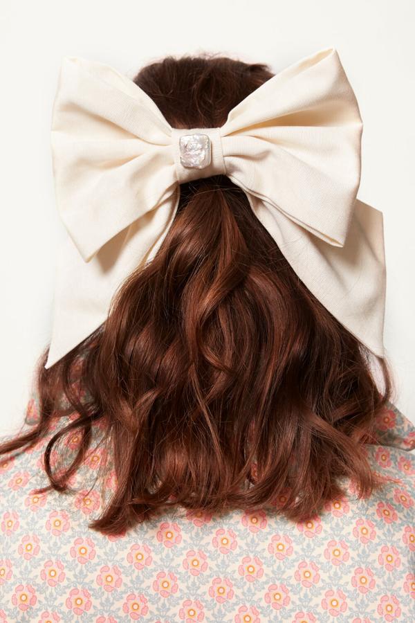 Un lazo XXL para el cabello en color blanco roto con una perla de adorno (80 libras, unos 91 euros). Fabricado a mano por la firma Margaux Studios, una marca especializada en joyería romántica con toque muy british, este accesorio para tu cabello es el más es más que necesitabas.