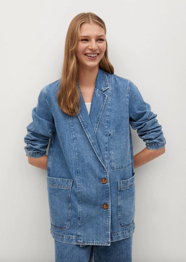 El denim vuelve para convertirse en imprescindible en nuestros looks de entretiempo y en Mango lo han llevado a esta americana en azul medio de diseño recto confeccionada al 100& en algodón. Con cuello de solapa, mangas largas, bolsillos de plastrón laterales y cierre de botones frontales a contraste, tiene un precio de 49,99 euros y está disponible entre las tallas XS y L.