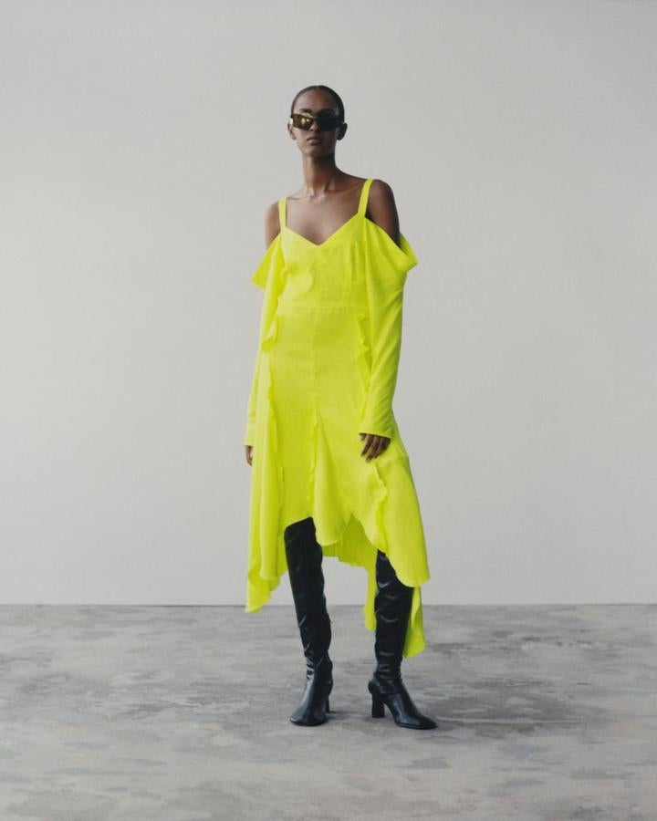 Vestido asimétrico de tirantes y manga larga con los hombros al aire, botas y gafas de sol, todo de la colección Studio SS21 de H&M