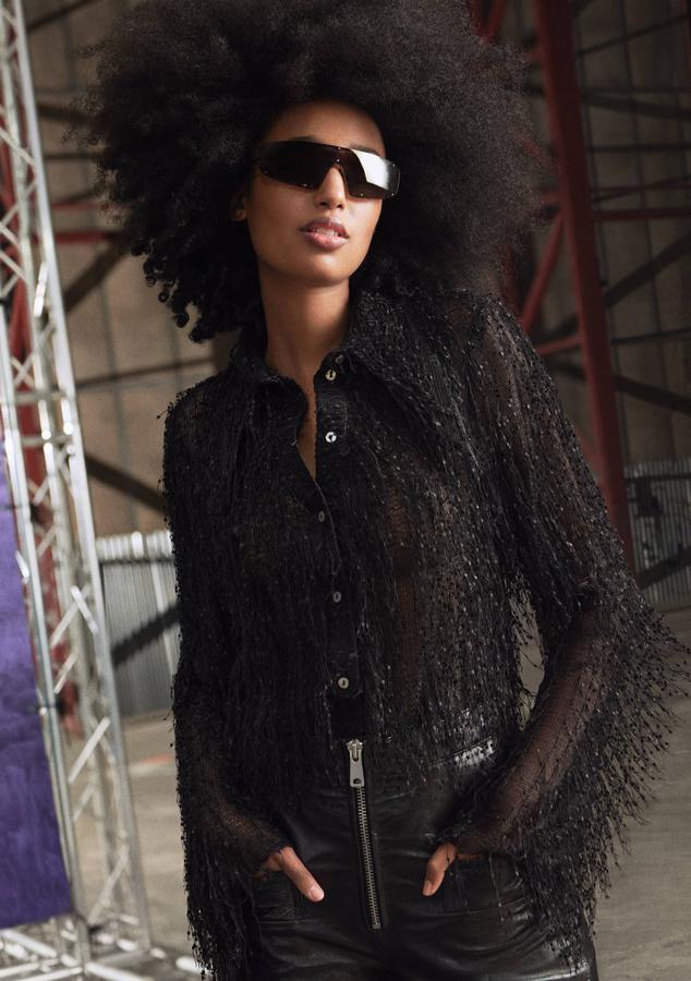 Camisa semitranparente con flecos, pantalón de cuero y gafas de sol, todo de la colección Studio SS21 de H&M.