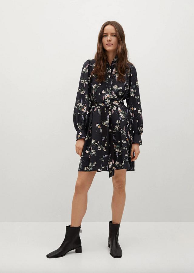 Este vestido mini confeccionado en tejido fluido en negro con estampado de flores blancas y rodas es de diseño recto y viene con cuello redondo, mangas largas acabadas en puños abotonados y cinturón desmontable a tono. Tiene un precio de 29,99 euros y está disponible entre las tallas XS y XL.
