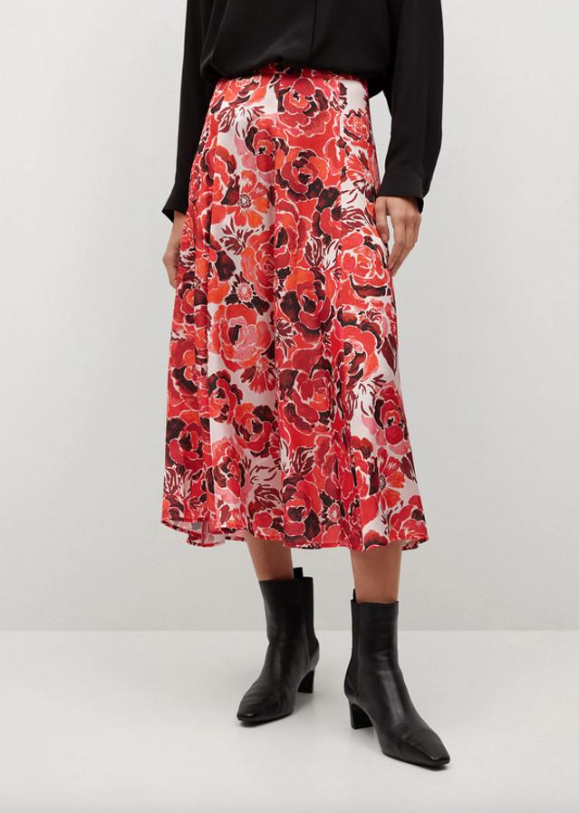 Con estampado de flores en tonos rojos sobre fondo blanco, esta falda de tejido fluido midi y acampanado de Mango viene con detalle de pliegues. Tiene un precio de 39,99 euros y está disponible entre las tallas XS y L.