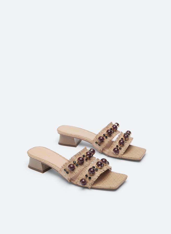 Estas sandalias de rafia con detalles joya están rebajadas en Uterqüe a 29.90 euros.