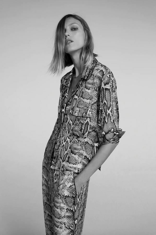 Esta blusa satinada de cuello y solapa con manga larga y bolsillos delanteros de plastrón es de Zara y tiene cierre frontal con botones. Podemos encontrarla entre las tallas XS y XL y cuesta 25,95 euros.