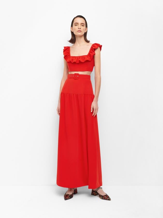 Como hemos visto en otra de las imágenes pero con otro estampado, ofrece este conjunto en rojo compuesto por falda tobillera y top cropped con volantes en el escote.