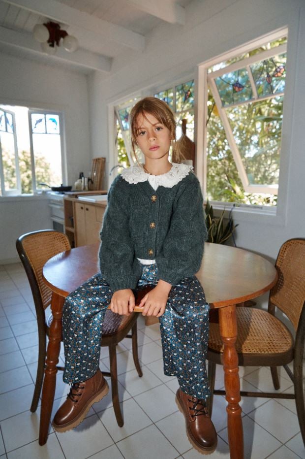 Esta chaqueta de punto con bodoques, manga en volumen y botones en contraste de Zara Kids es una de nuestras favoritas para ir a juego con nuestras hijas. Cuesta 25.95 euros.