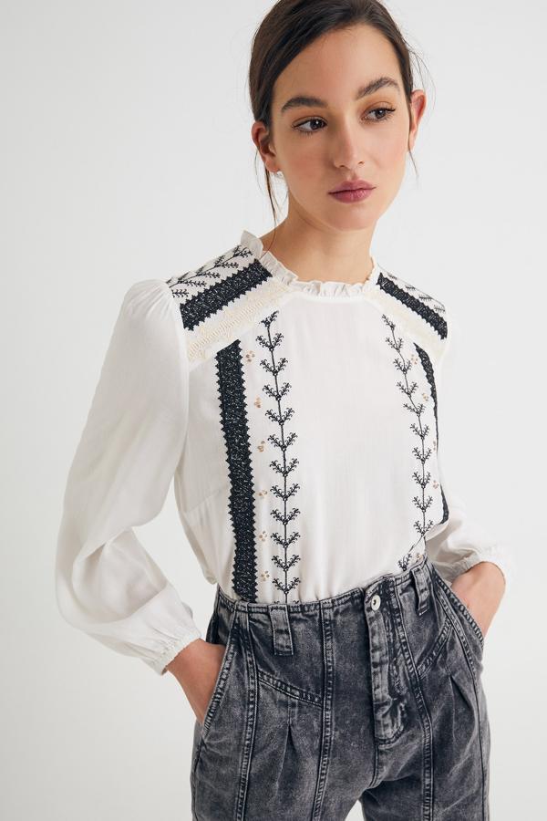 Con cuello perkins y detalle de bordado en negro, esta camisa blanca de manga larga con elástico en el puño tiene un precio de 19,99 euros.