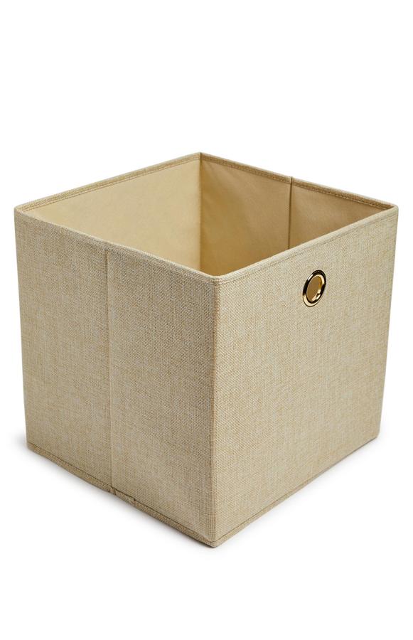De tela en color beige, esta caja cúbica de almacenaje tiene un precio de 3,50 euros.